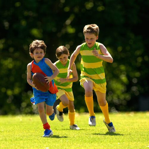 Children playing football on the field.