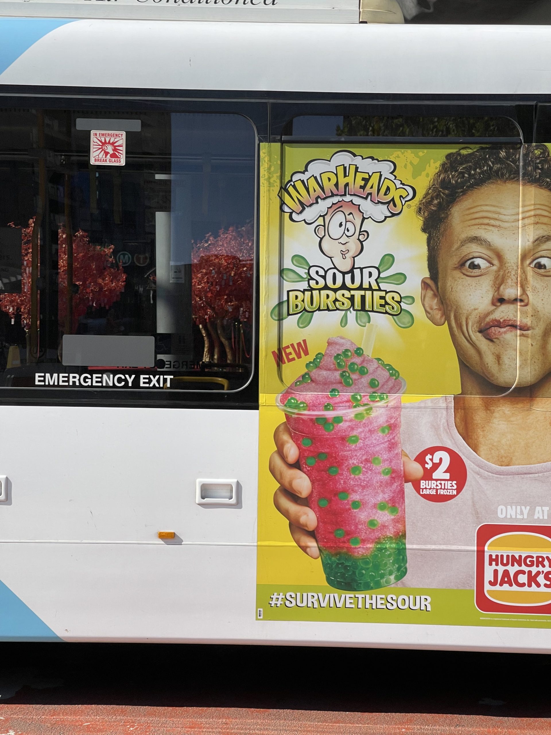 An ad on a bus of a boy holding a bursties frozen drink